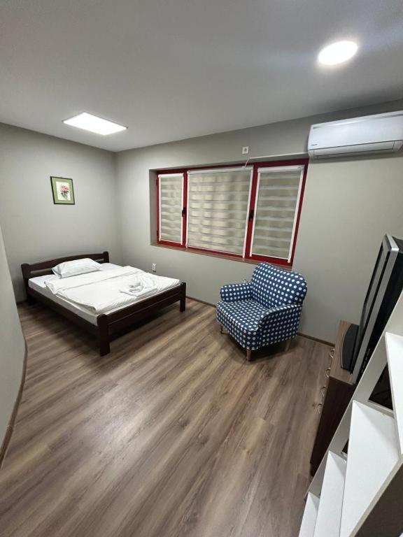 a bedroom with a bed and a chair in it at Апартамент за гости КРИСИ - Apartment for rent KRISI in Vidin