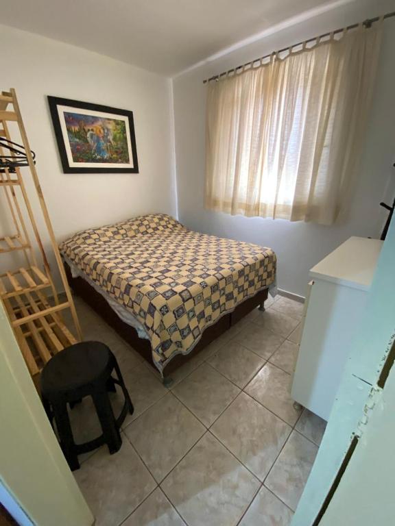 a small bedroom with a bed and a chair at Riacho Fundo 1 - Riacho Mall in Brasília