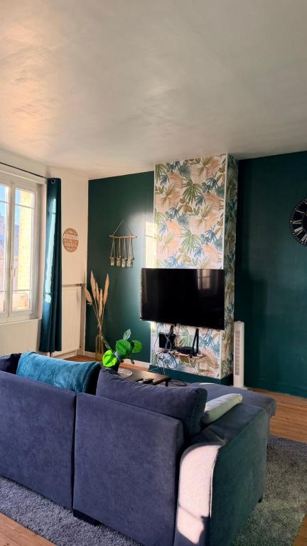a living room with a blue couch and a tv at Au coeur d'Harfleur 2 in Harfleur