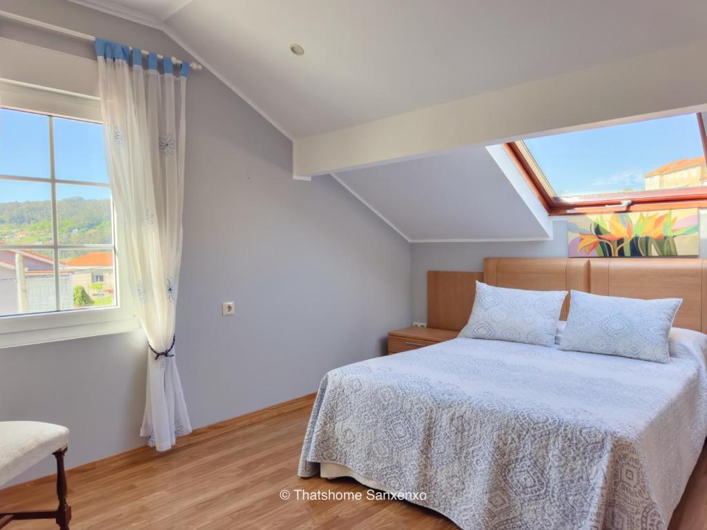 a bedroom with a bed and a window at Chalet Sobre do Valo in Sanxenxo