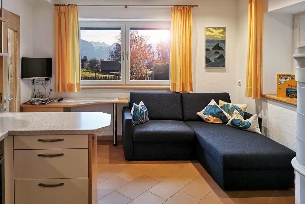 a living room with a couch and a desk at Biene Natururlaub am Moosbachhof mit Dolomitenblick in Collalbo