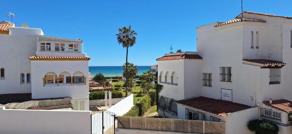 a view of two white buildings and the ocean at A & G Casares Costa in San Luis de Sabinillas