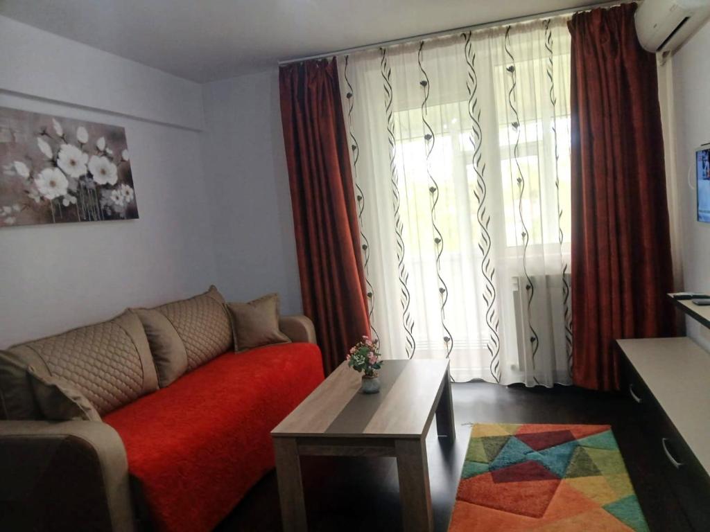 a living room with a red couch and a window at APARTAMENt ULTRACENTRAL in Tulcea