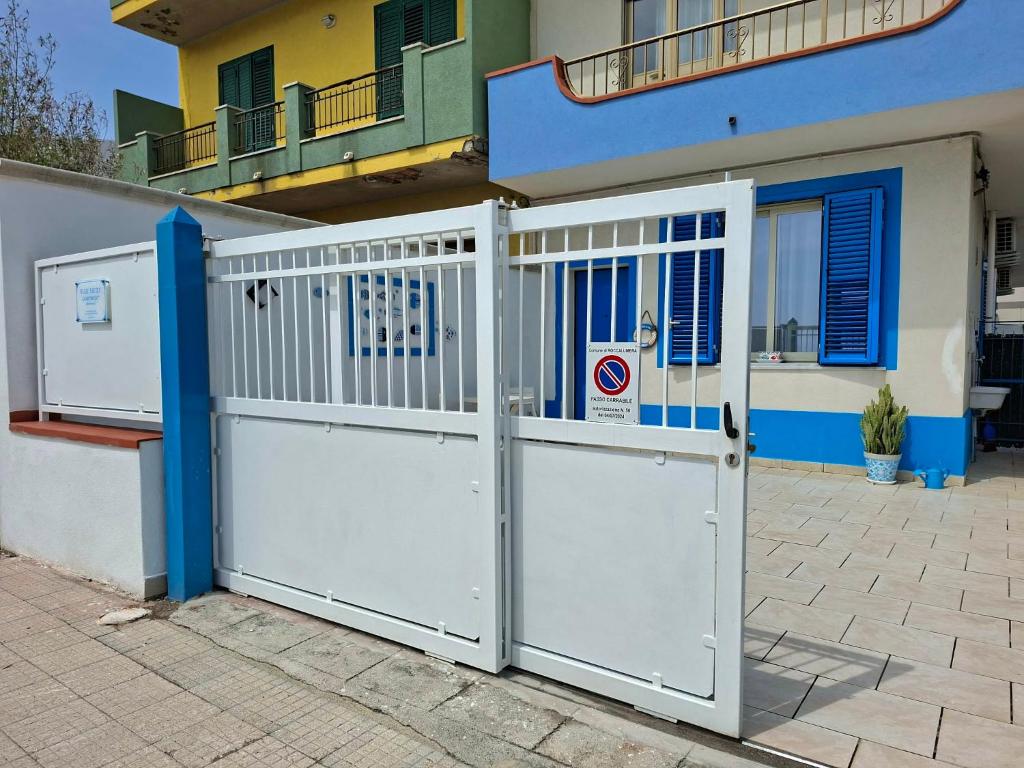 a white gate in front of a house at Blue Sicily Apartment in Roccalumera