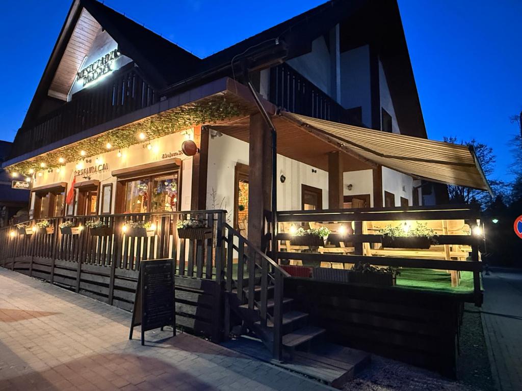 a restaurant with lights on the side of a building at Bieszczadzki Dworek Polanczyk in Polańczyk