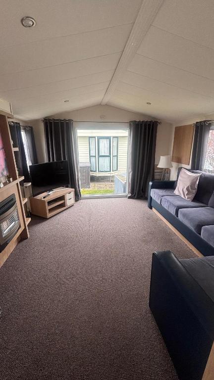 a living room with a couch and a tv at Lyons Robin Hood Hazel Park 6 in Rhyl