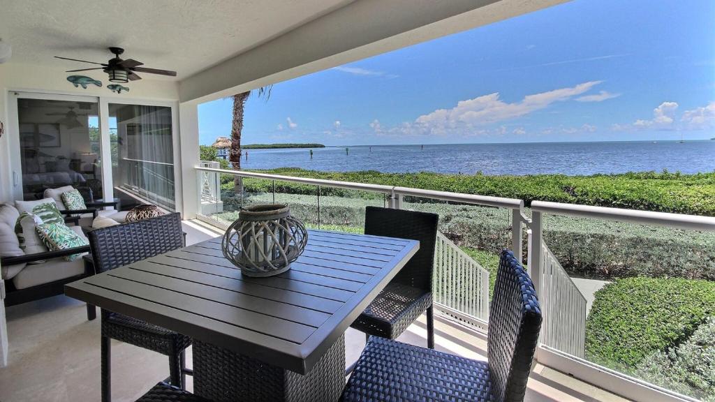 a porch with a table and chairs and the ocean at 311 Mariners Club in Key Largo