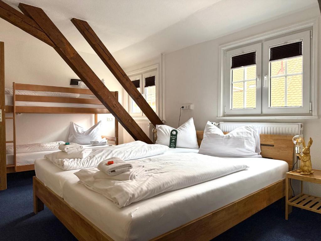 a bedroom with two beds and two windows at Hotel Hasen Kaufbeuren Allgäu in Kaufbeuren
