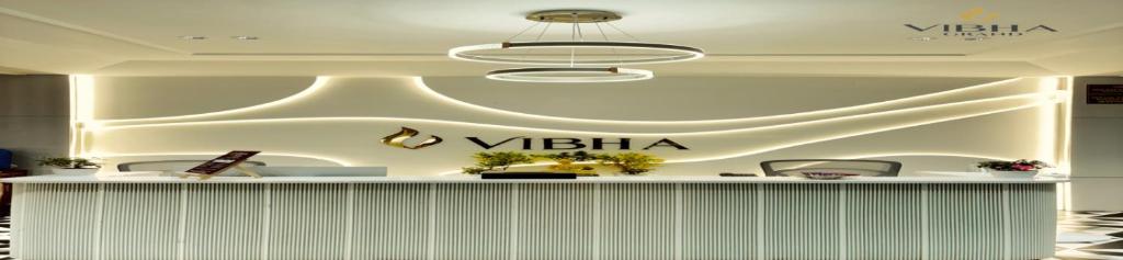 a lobby with a vita sign on the wall at Hotel Vibha Grand in Karīmnagar