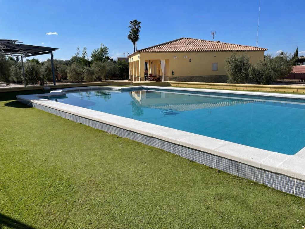 a swimming pool in a yard next to a house at Villa rural en Marchena in Marchena