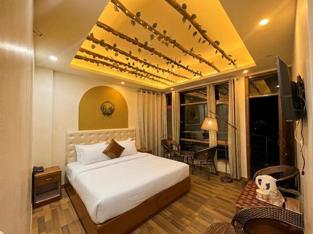 a bedroom with a bed and a desk and a television at Siesta B&B Private Balcony & Himalayan Sunrise Views in Shimla