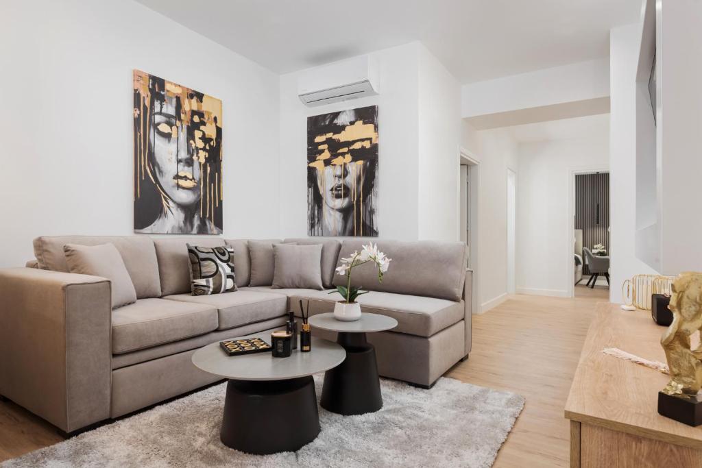 a living room with a couch and two tables at Aura Airport Suite in Spata