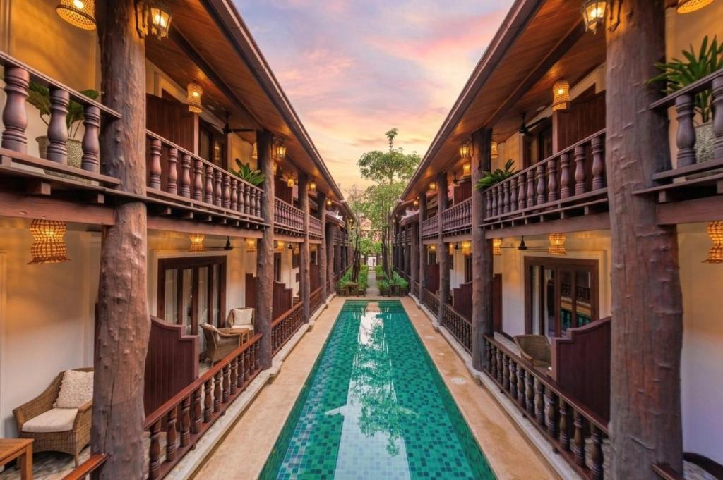 a corridor of a building with a pool in the middle at Treasure Heritage Luang Prabang Hotel in Luang Prabang