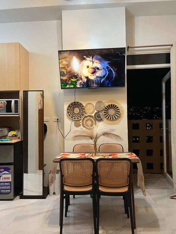 a dining room table with chairs and a tv on the wall at Cozy Loft Studio with Balcony in Cebu City in Cebu City