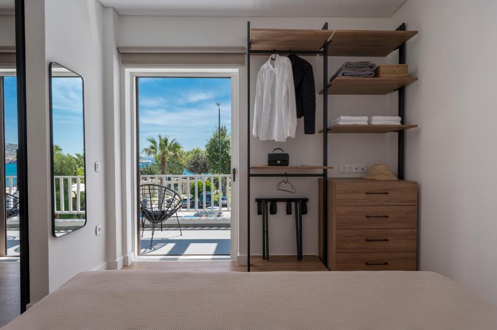 ein Schlafzimmer mit einem Bett, einer Kommode und einem Fenster in der Unterkunft WALK2BEACH Riviera Beachfront Luxury Studio Suite - Steps to Yabanaki Varkiza in Varkiza
