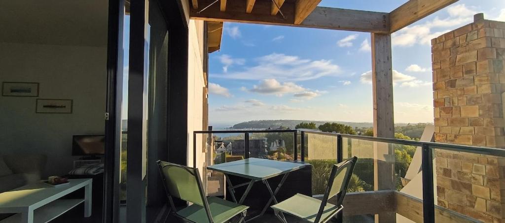 ein Balkon mit Tisch und Stühlen und Aussicht in der Unterkunft Appartement neuf avec balcon - Vue mer - Crozon in Crozon