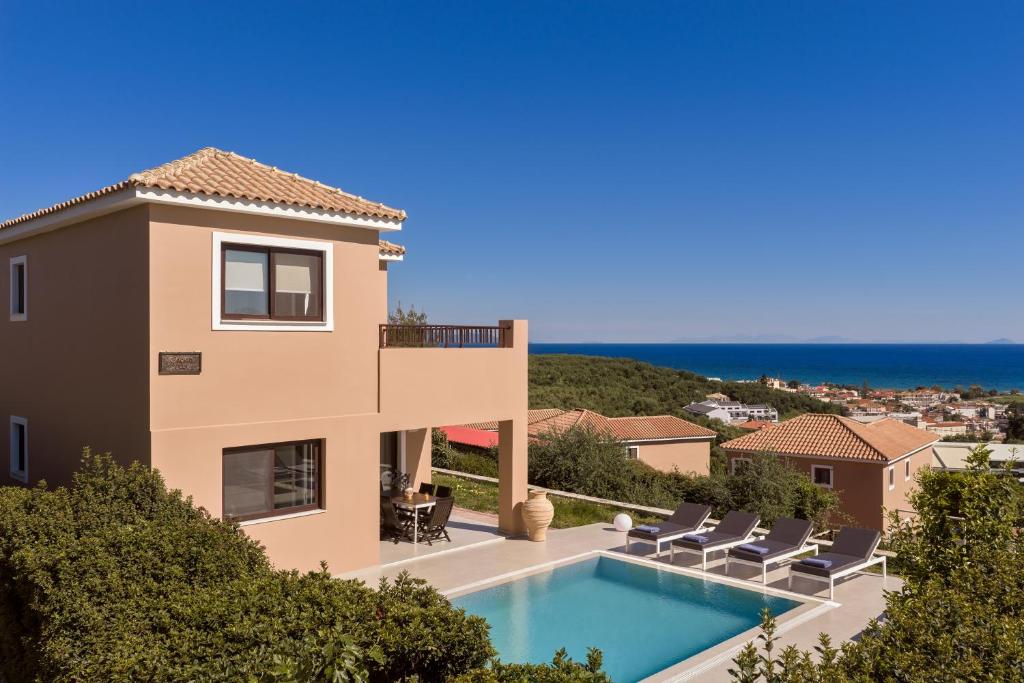 a villa with a swimming pool and a view of the ocean at St John Villas Zakynthos in Tsilivi