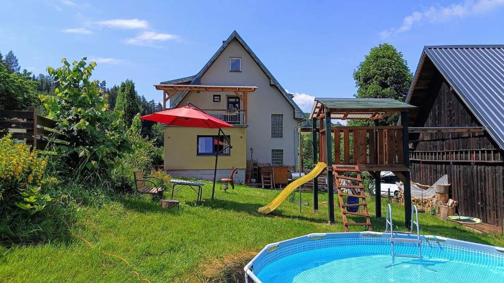 a backyard with a pool and a house at Wellness apartmán TERASA in Bozkovska