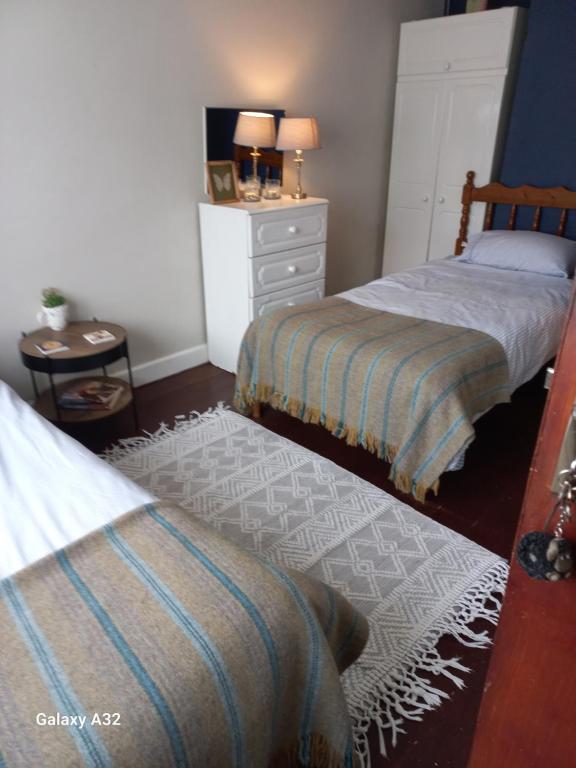 a bedroom with two beds and a dresser at Fishing in Foxford