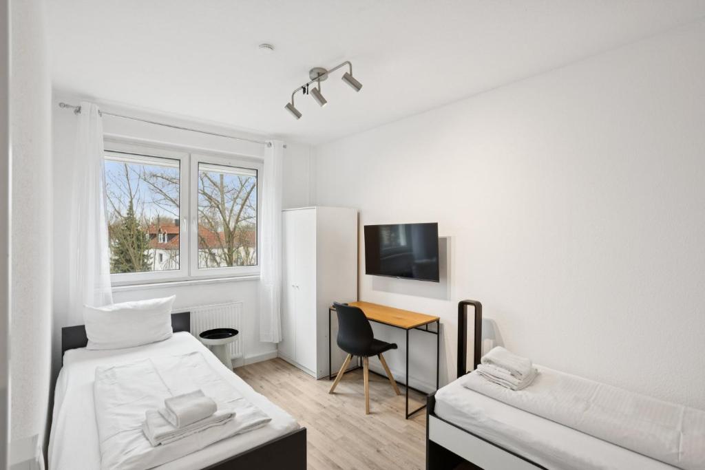 a white room with a bed and a desk at Am Ring Monteurzimmer Apartment Böhlen in Böhlen