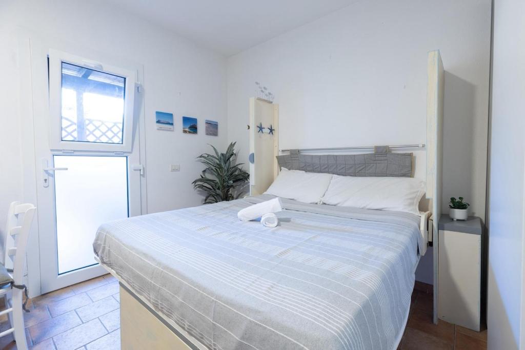 a white bed in a room with a window at Sibilla house 2 in Olbia