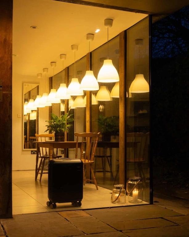 a suitcase sitting on a patio with a table and lights at The Nook in South Cerney