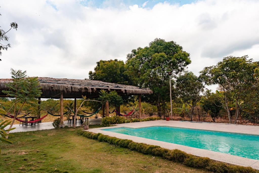 a swimming pool with a pavilion and a playground at Finca La Macarena, Playas Villamil in Playas