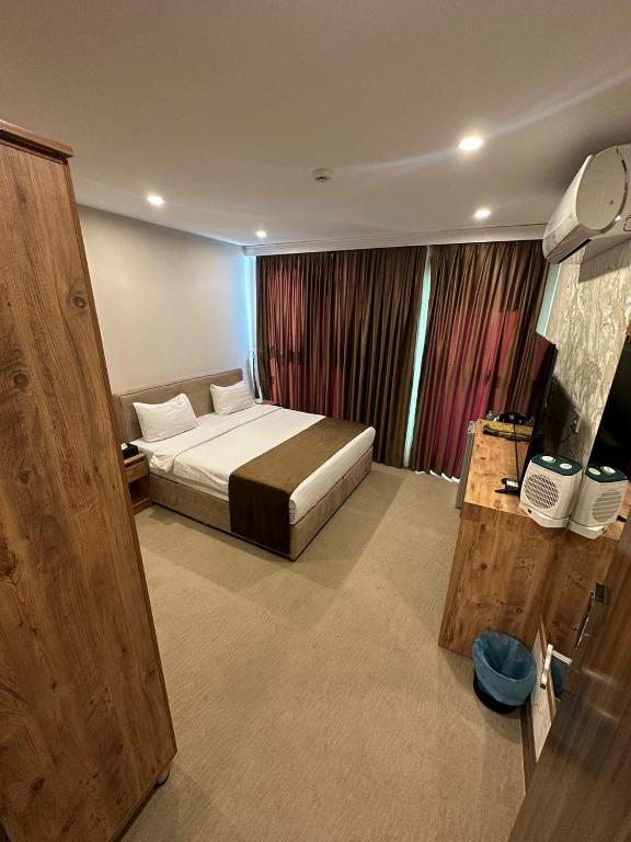 a hotel room with a bed and a television at Ward Hotel Basra in Al Başrah