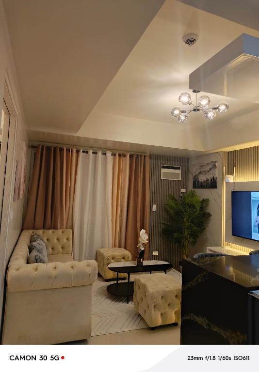 a living room with a couch and a tv at Davao city One Lakeshore Drive at the back of sm lanang in Davao City