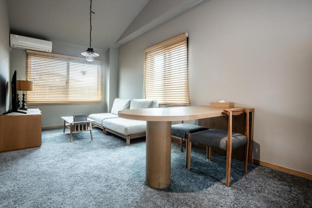 a living room with a table and a couch at Yado Arashiyama -13 years old or older only- in Kyoto