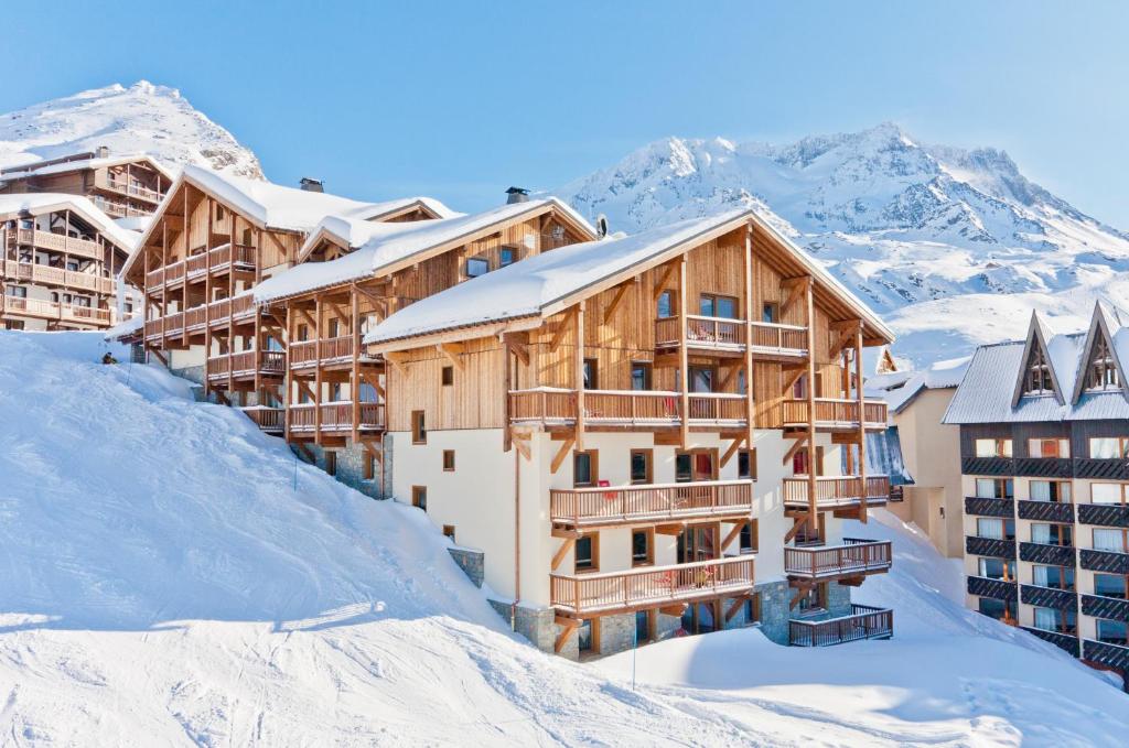 a resort in the snow with mountains in the background at Residence Montana Plein Sud in Val Thorens