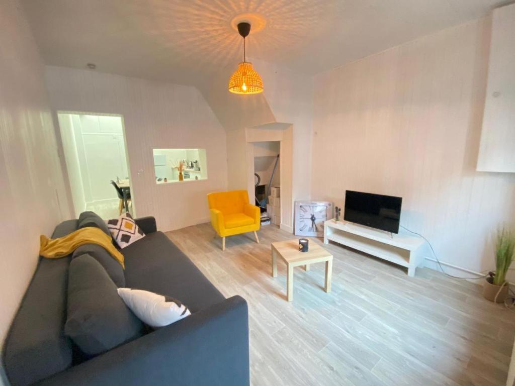 a living room with a couch and a yellow chair at L'Apart Amiens in Le Treuil