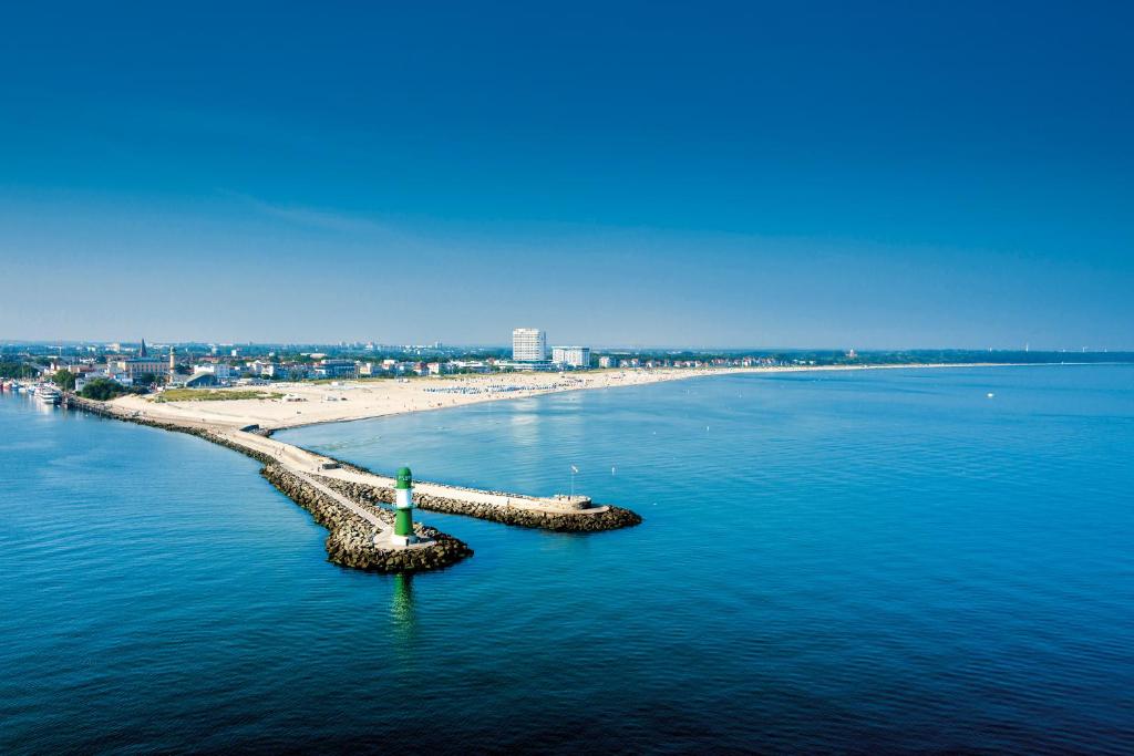 a beach with a lighthouse in the middle of the water at Hotel Neptun in Warnemünde