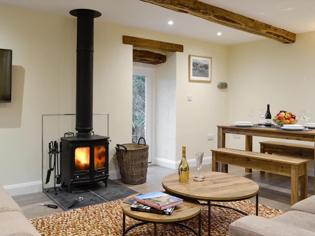 a living room with a wood stove in it at Tarn Rigg Cottage - Uk1368 in Keswick