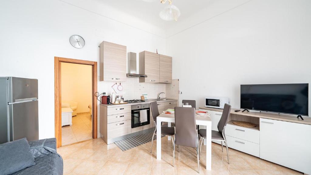 a kitchen and dining room with a table and chairs at Casa Alessia by Rentbeat in Cisternino