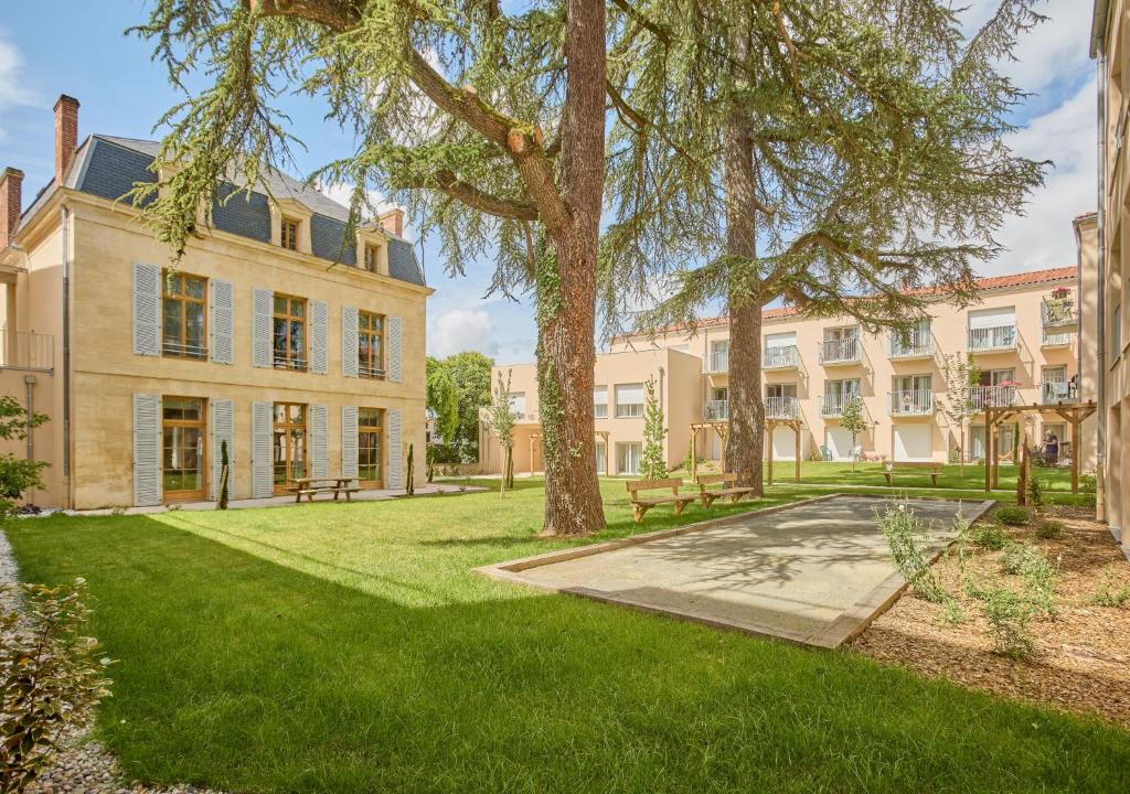 an exterior view of a large building with trees at Résidence de Bergerac in Bergerac