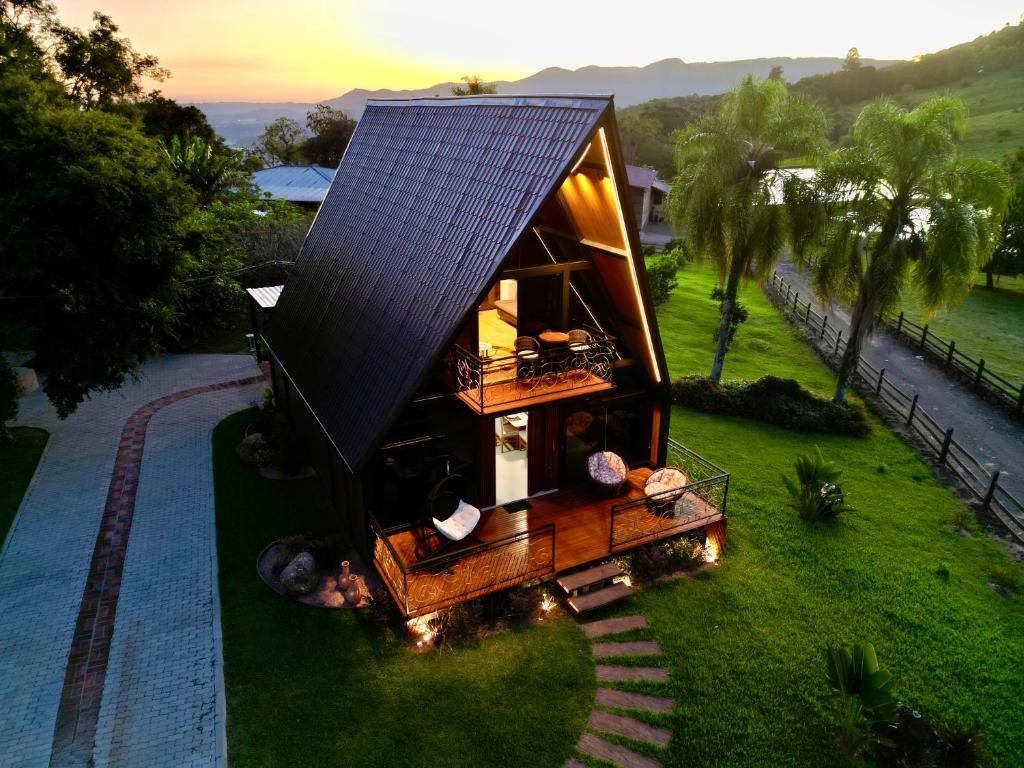 a tiny house with a solar roof on the grass at Cabana Silêncio das Pedras in Três Coroas