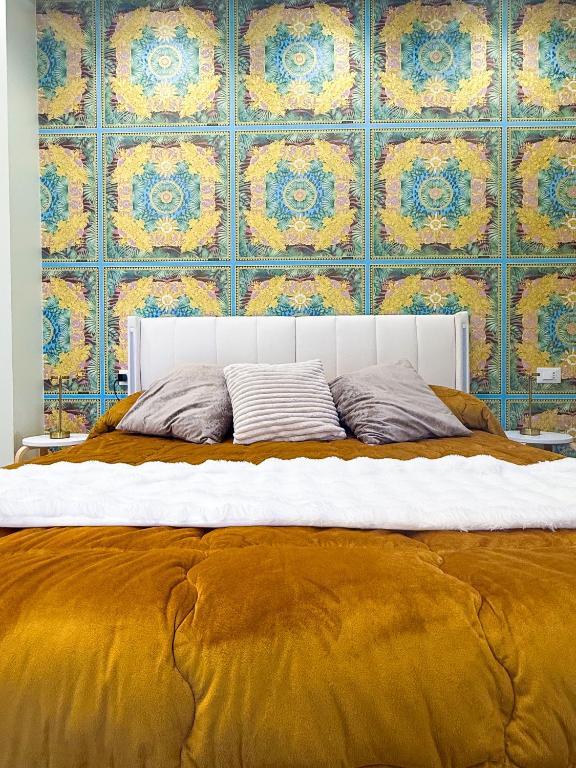 a large bed with a yellow and blue wall at La Chicca di Ameli in San Severo
