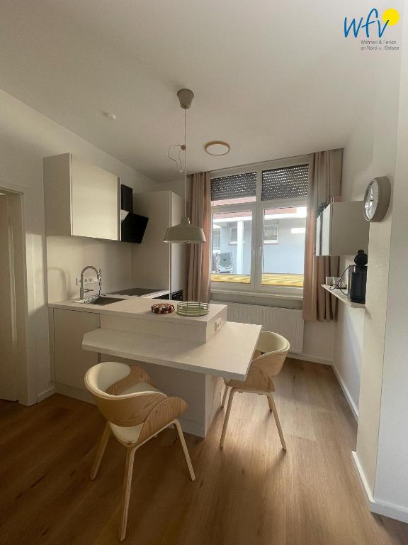 a kitchen with a white table and two chairs at Stine's Hus Ferienwohnung 1 in Borkum
