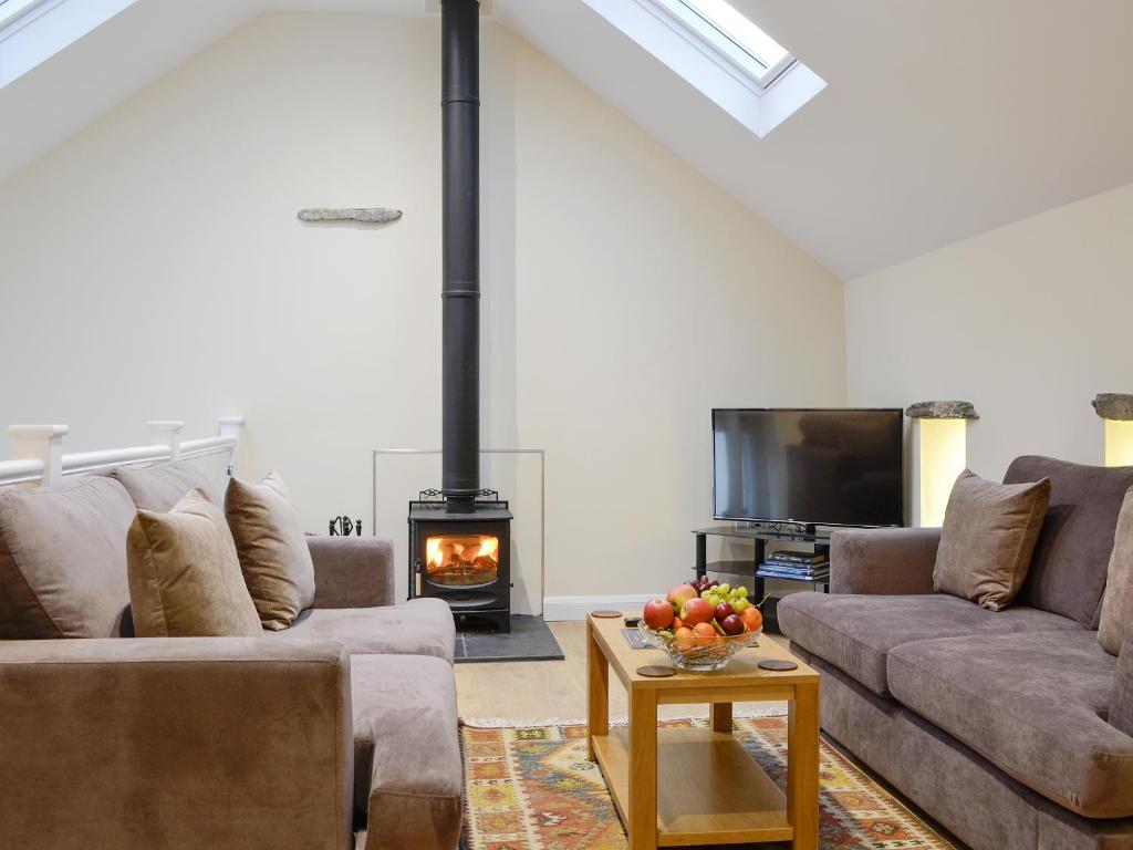a living room with two couches and a fireplace at Mary Rook Cottage - Uk1369 in Keswick