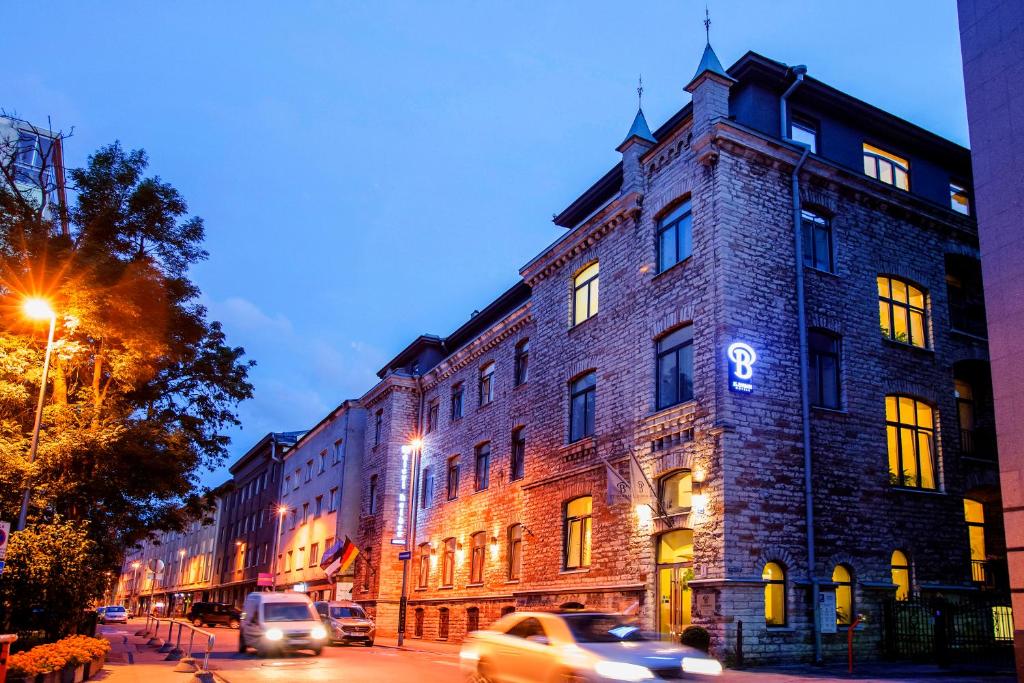 a large brick building on a city street at night at Hotel St. Barbara in Tallinn