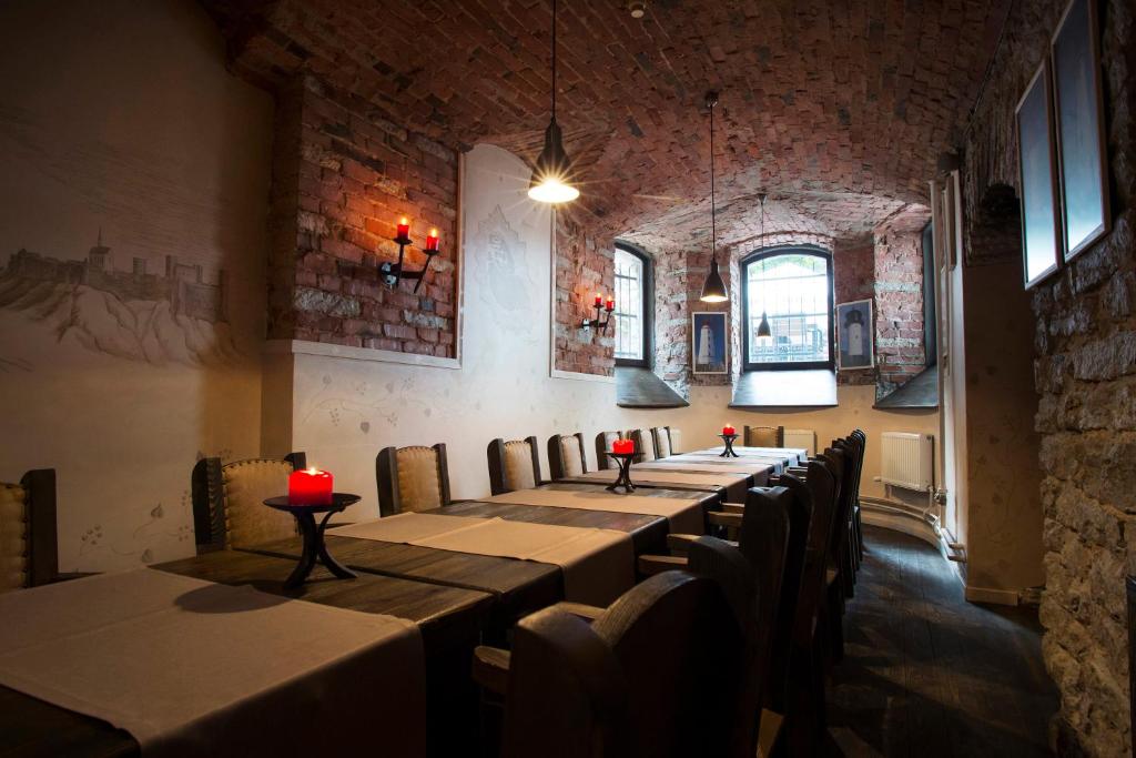 a row of tables in a room with windows at Hotel St. Barbara in Tallinn
