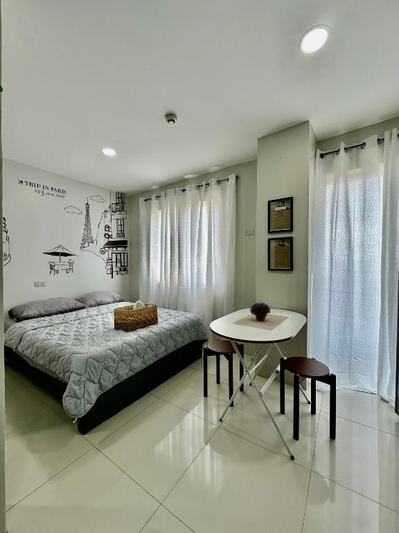 a bedroom with a bed and a table in it at TWD 716 Cityscape in Bacolod