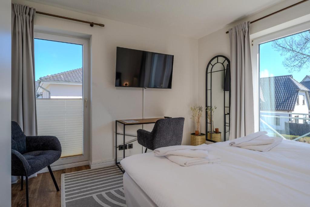 a bedroom with two beds and a large window at Johouse Zingst Johouse Zimmer 07 in Zingst