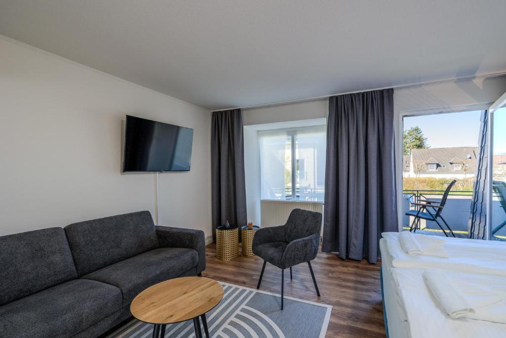 a living room with a couch and a tv at Johouse Zingst Johouse Zimmer 21 in Zingst