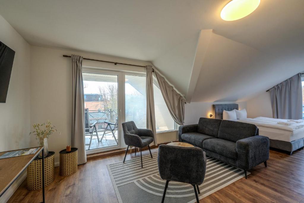 a living room with a couch and a bed and a balcony at Johouse Zingst Johouse Zimmer 15 in Zingst