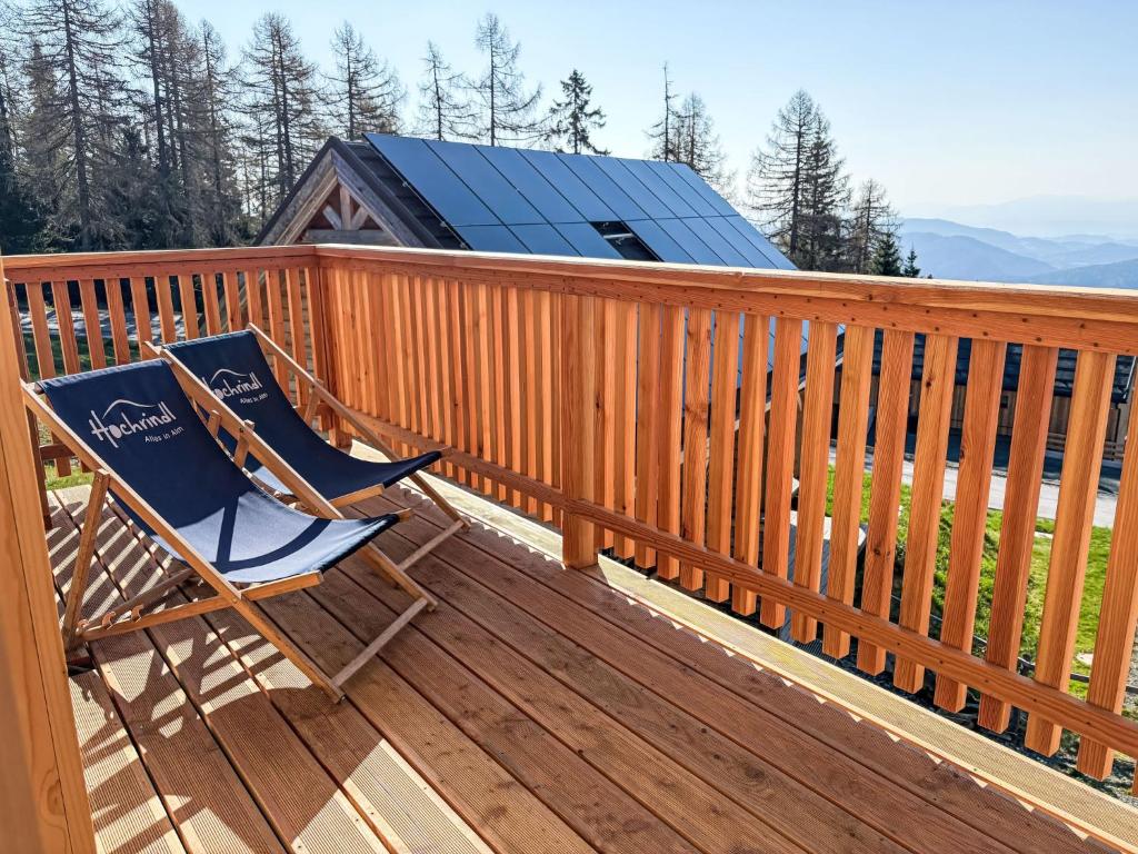 a rocking chair on a deck with a solar roof at Chalet Nockhütte by Interhome in Hochrindl