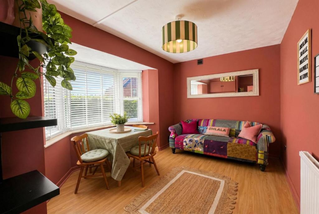 a living room with a couch and a table at Central Brockenhurst Village Flat with Free Parking in Brockenhurst