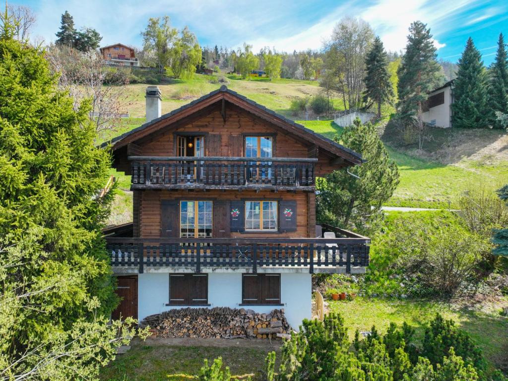 a large wooden house with a balcony at Chalet Chalet Le Trèfle by Interhome in Salins