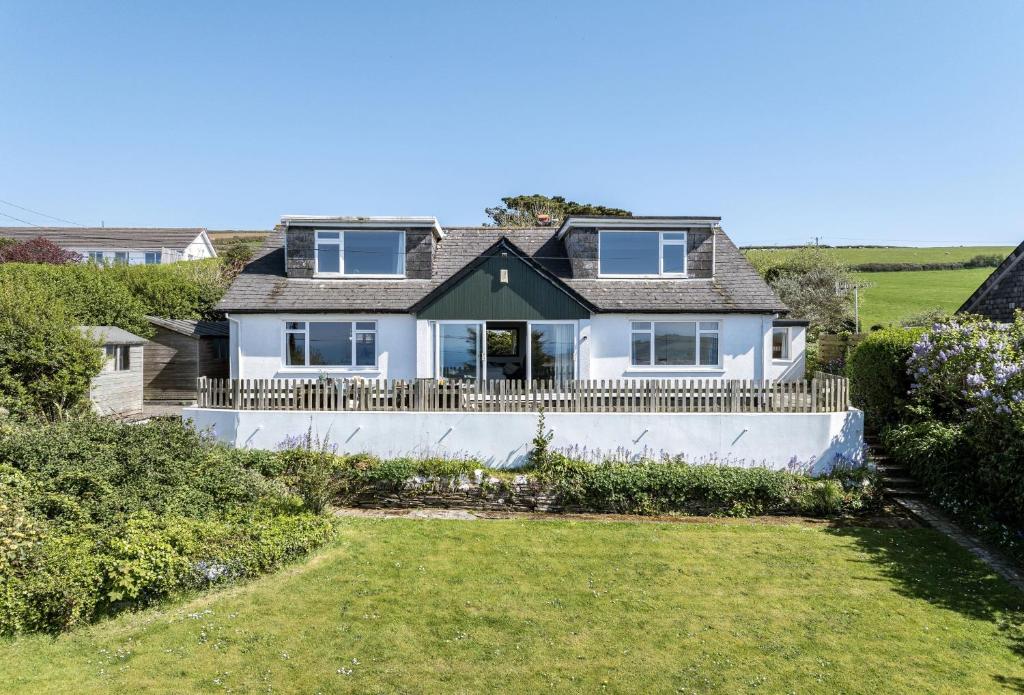 a white house with a fence and a yard at Boskenna in Tintagel
